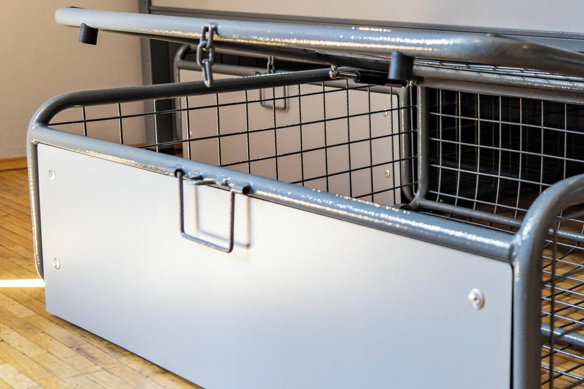 A bunk bed with a pull-out storage unit beneath it.