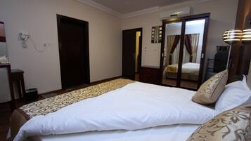 Una habitación de hotel con una cama grande, un escritorio y un armario.