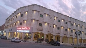 A multi-story building with a sign for "Tala Serviced Apartments."