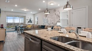 A modern kitchen with granite countertops, stainless steel appliances, and pendant lighting. - PROMO: BSV_1707Fireworks! 6BR Villa  - by Blue Sky Villas (Davenport)