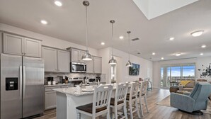 A modern kitchen with stainless steel appliances, white cabinetry, and pendant lighting. - PROMO: BSV_1707Fireworks! 6BR Villa  - by Blue Sky Villas (Davenport)