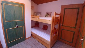 A room with a bunk bed, a wooden door, and a small clock on the wall. - Apartment in the Megeve valley (Praz-sur-Arly)