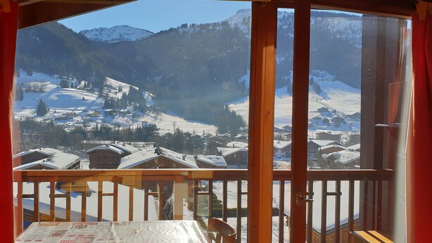 A room with a view of a snowy mountain landscape through large windows. - Apartment in the Megeve valley (Praz-sur-Arly)