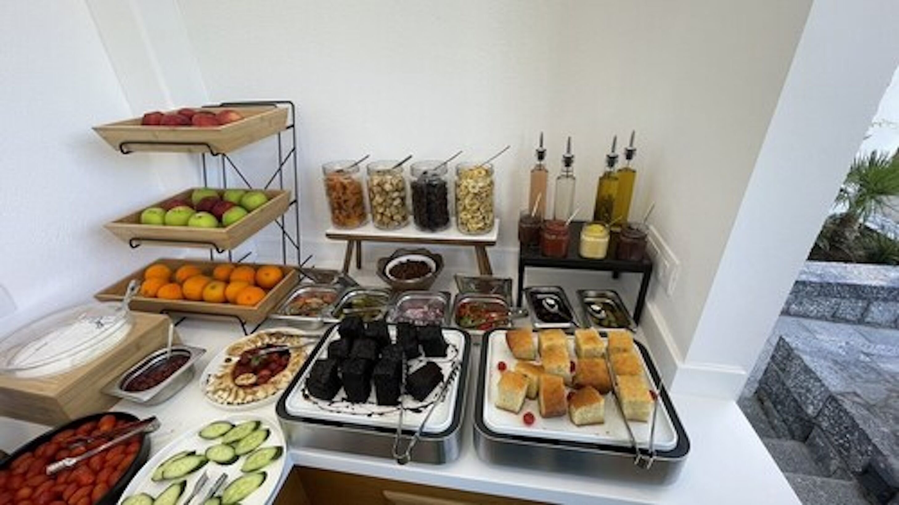 A buffet with various food items including fruits, vegetables, and condiments.