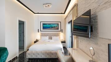 Habitación de hotel moderna con una cama grande, un televisor montado en la pared y suelo de mármol.