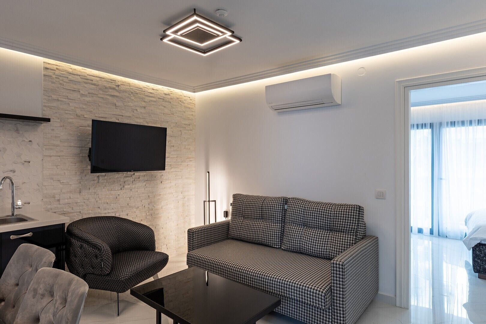 Una sala de estar moderna con sofá, sillón y mesa de centro.