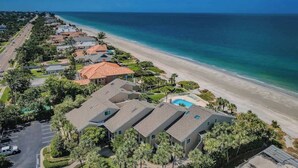 Una zona residencial costera con casas, una playa y una piscina.