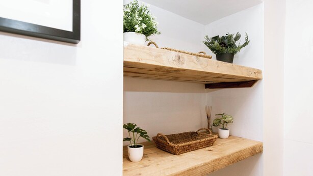 Een houten plank met potplanten en een rieten mand.