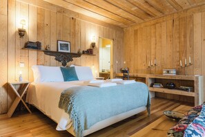 A wooden-paneled room with a bed, bedside tables, a mirror, and a shelf with books and candles. - Casa do Salgueiral (Santa Marta de Penaguião)