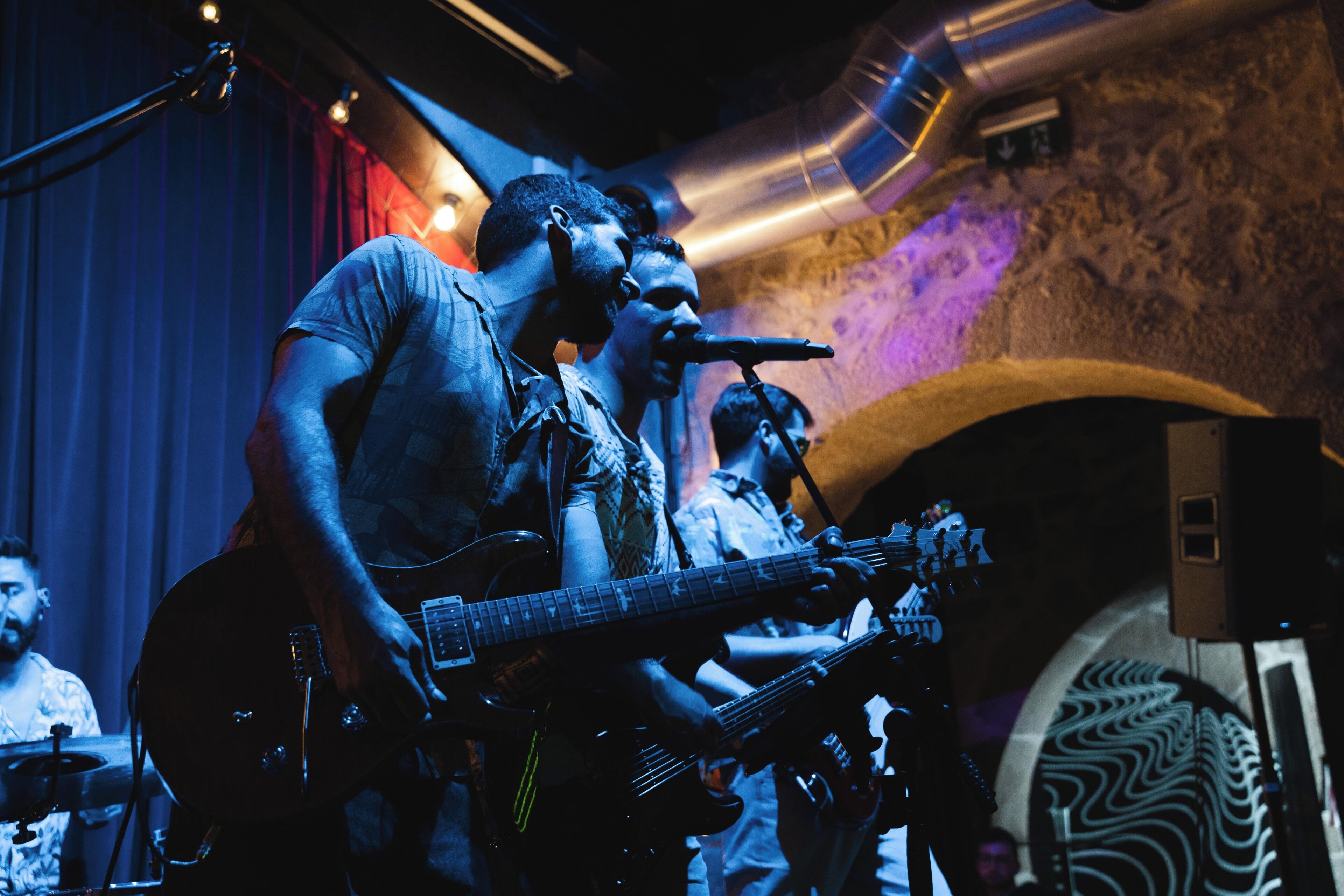 A band performing on stage with musical instruments and a microphone.