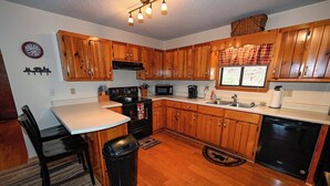A kitchen with wooden cabinets, a stove, a microwave, and a dishwasher. - Close to Town • Mountain Views • Fast Wifi • Pet Friendly (Murphy)