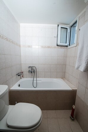 Bathtub, hair dryer, towels, shampoo