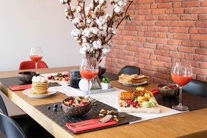 Una tavola imbandita con diversi cibi e bevande, tra cui una ciotola di cereali, pasticcini e un bicchiere di bevanda rossa.