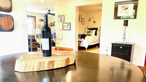 Una cocina con una mesa redonda, una botella de vino y copas sobre una tabla de madera.