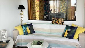 A living room with a sofa, a small round table, and a lamp. - T.2 SUPERB SEA VIEW "COCOONING FAVORITE" CLASS 2 STARS!!!! (La Grande-Motte)