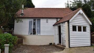 A single-story house with a red-tiled roof, a small attached garage, and a front porch.