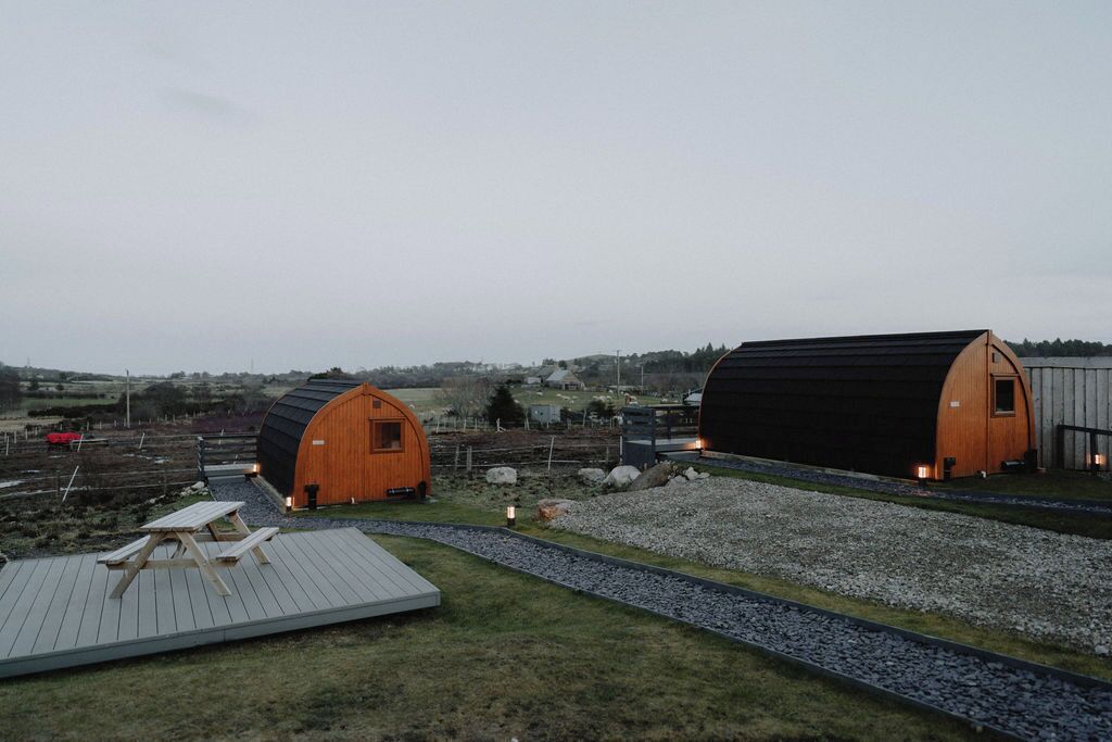 Un cadre rural avec deux cabanes en bois et une table de pique-nique.