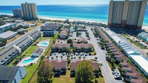 Un resort con diversi edifici, una piscina e vista sulla spiaggia.