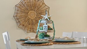 Un tavolo da pranzo con piatti, un centrotavola decorativo e un elemento decorativo appeso al muro.