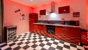 A kitchen with red cabinets, a checkered floor, a microwave, and a refrigerator. - Marilyn Monroe Suite - 4P with Private Jacuzzi (Montry)