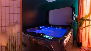 A hot tub with a control panel, surrounded by a wooden partition and a potted plant. - Marilyn Monroe Suite - 4P with Private Jacuzzi (Montry)