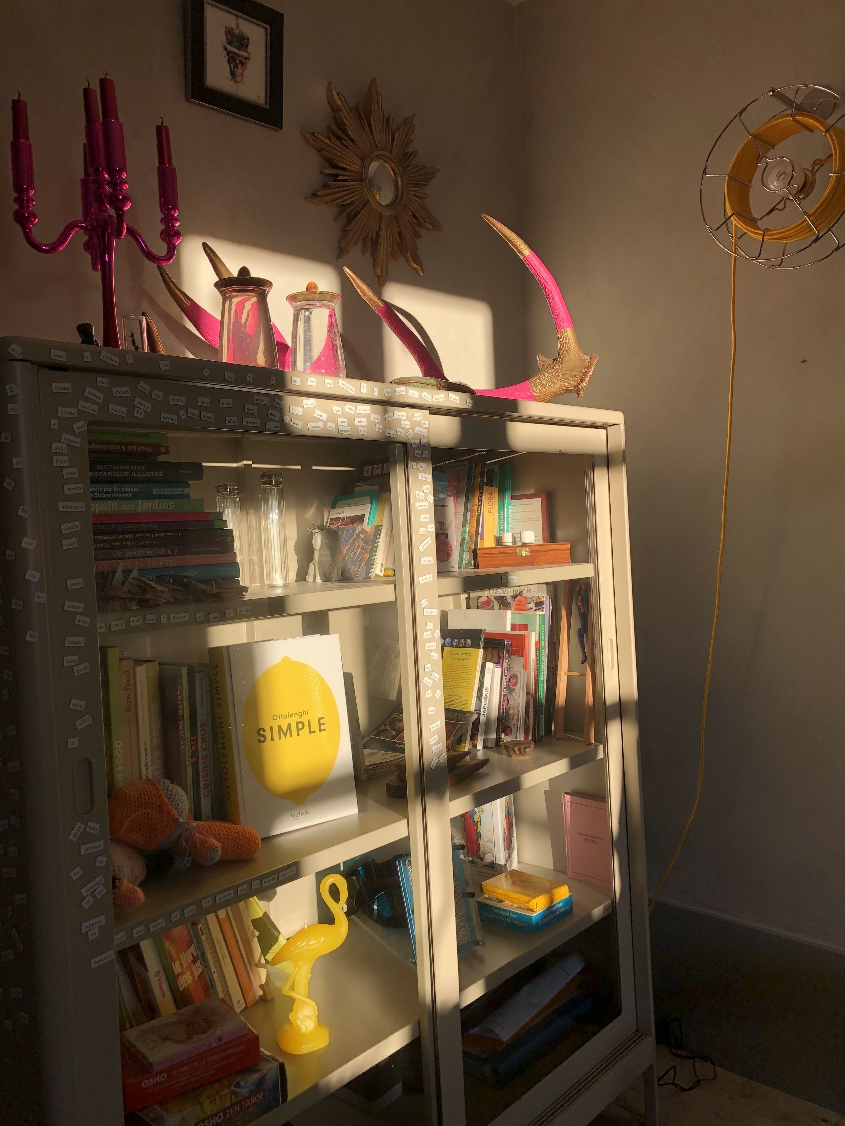Een boekenkast met verschillende boeken, decoratieve objecten en een geel object met de tekst 'Simple'.