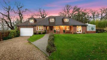 A two-story house with a garage, a front porch, and a well-maintained lawn.