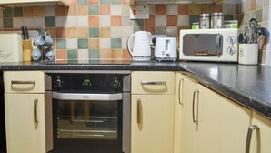 A kitchen with a microwave, coffee maker, and oven. - 3 bedroom accommodation in Sheringham (Sheringham)