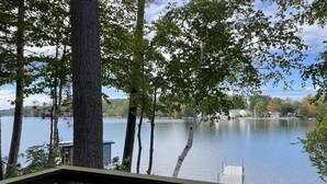Une vue sur un lac, avec un quai et un bâtiment en arrière-plan.