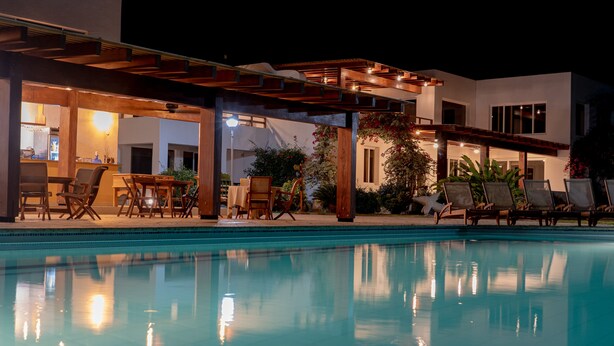 A poolside area with lounge chairs, a bar, and a covered seating area. - Hosteria del Parque Machalilla - Los Frailes (Machalilla)