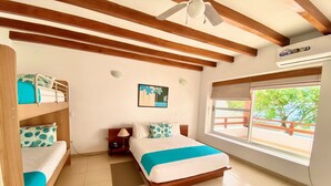 A room with a bed, a bunk bed, a window with a view, and a ceiling fan. - Hosteria del Parque Machalilla - Los Frailes (Machalilla)