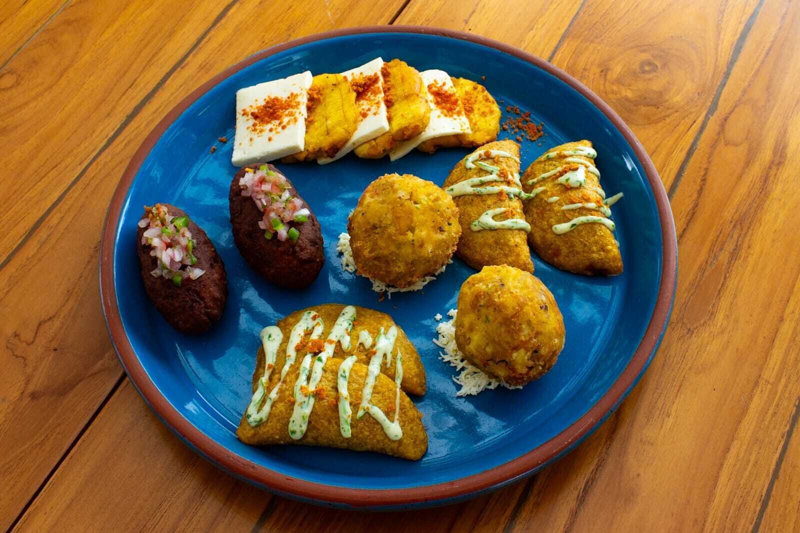 A blue plate with various food items on a wooden table.