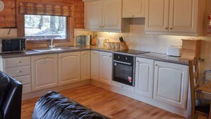 Eine gemütliche Küche mit Holzausstattung, einer Mikrowelle, einem Toaster und einer Kaffeemaschine.