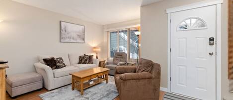 Living room with a Smart TV, cozy seating options and a full-sized sofa bed (all linens provided.)