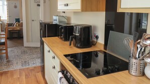 A modern kitchen with a black induction cooktop, a coffee maker, and a toaster. - North Terrace (Saltburn-by-the-Sea)