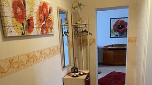 A narrow hallway with a wooden cabinet, a mirror, and a red carpet. - Colorful city on the Elde 2 (Grabow)