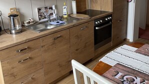 A compact kitchen with wooden cabinets, a stainless steel sink, and a built-in oven. - Colorful city on the Elde 2 (Grabow)