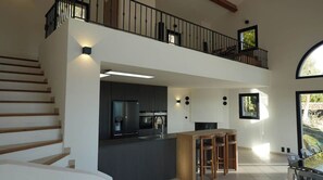 Un grand espace de vie comprenant une cuisine, un coin repas et un balcon avec vue.