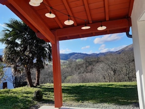 Un espace extérieur abrité offrant une vue sur un paysage montagneux.