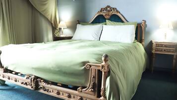 Uma cama de dossel clássica com entalhes decorativos, roupa de cama verde e duas mesas de cabeceira com abajures.