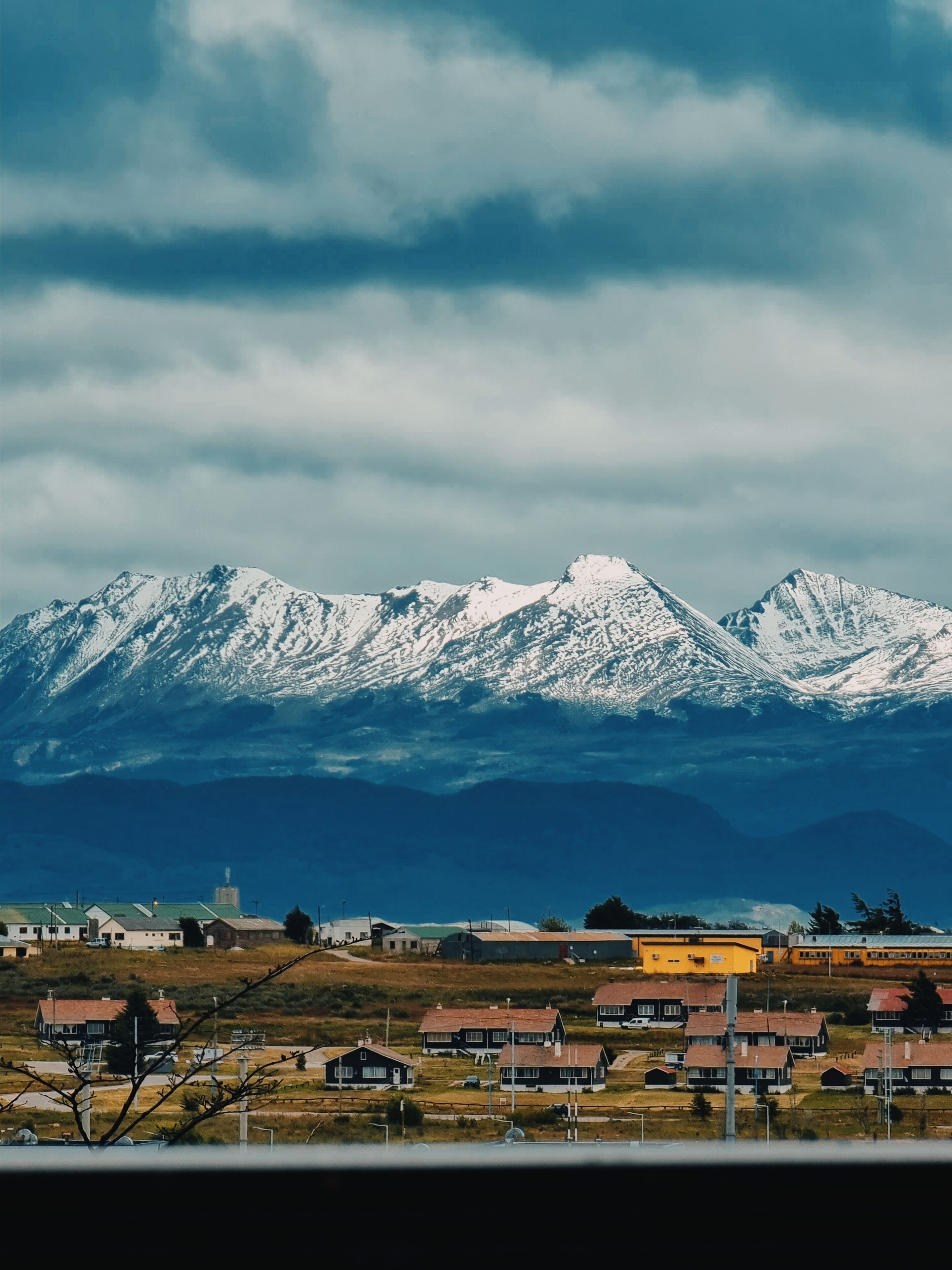 A town with houses and a mountain range in the background.