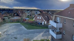 A residential area with houses, a paved driveway, and a grassy area.