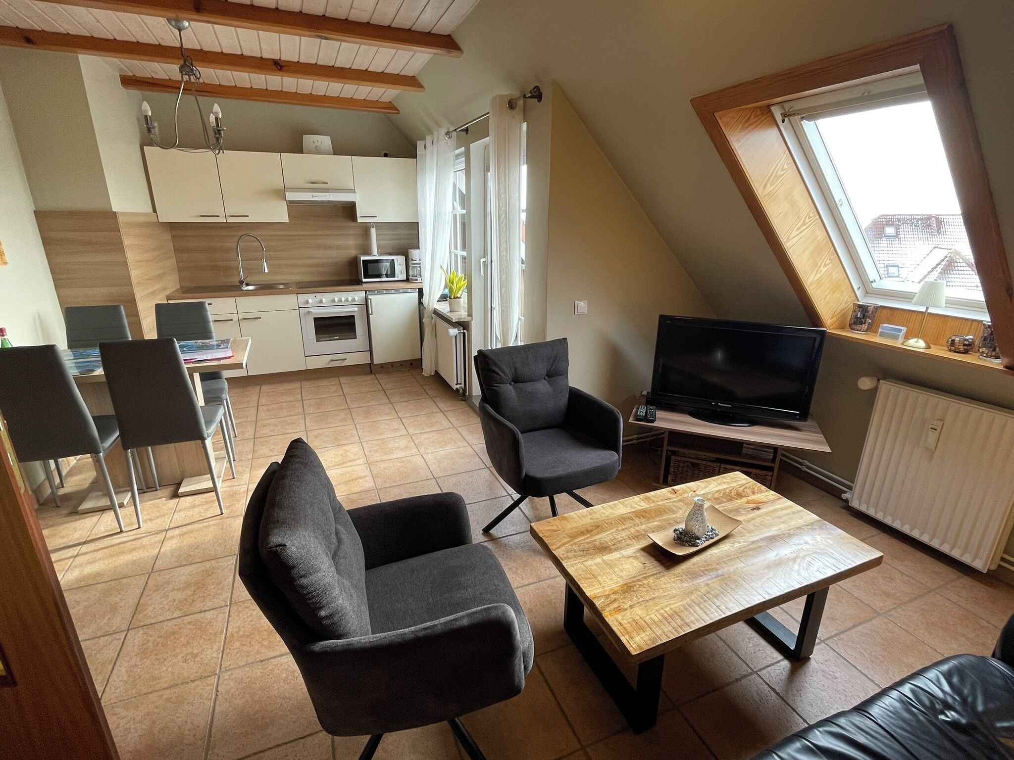 A compact living space with a kitchen, dining area, and a TV.