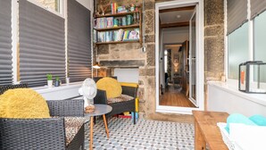 Une pièce chaleureuse avec une bibliothèque, des meubles en osier et un sol à motifs.