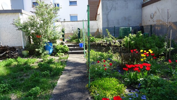 A garden pathway leading to a building with multiple windows and a balcony. - Relaxed living in a centrally located apartment (Kleinblittersdorf)