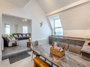 Een modern appartement met een woonkamer, eetgedeelte en keuken.