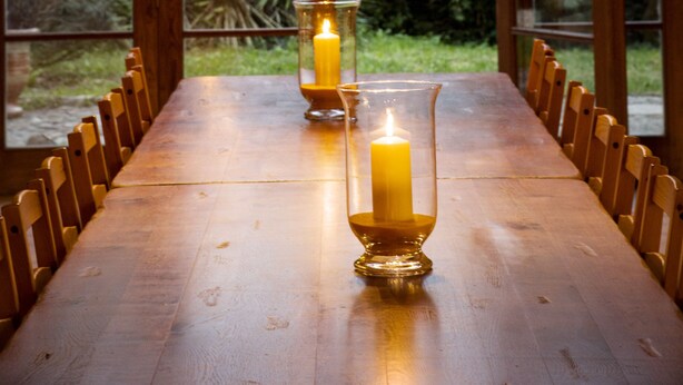 A dining table with candles and a chandelier in a room with large arched windows. - Restored farmhouse, fenced garden 1.8 Ha, private swimming pool (Orthevielle)