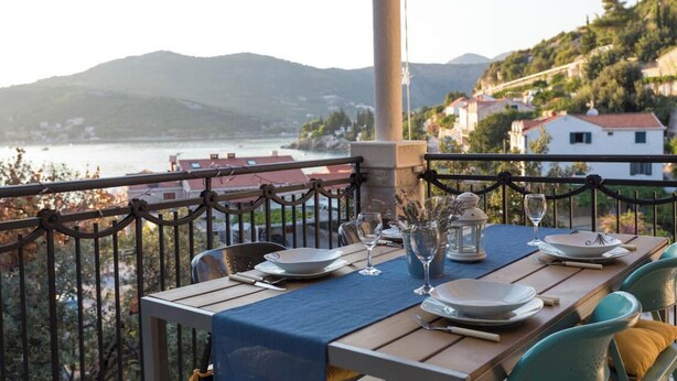 A table set for dining with a view of a lake and hills. - Fig&Olive Apartments 2 (Zaton)