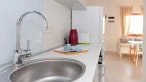 A modern kitchen with a stainless steel sink, a red kettle, and a white refrigerator. - Fig&Olive Apartments 2 (Zaton)