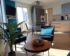 A modern living room with a sofa, a coffee table, and a potted plant.